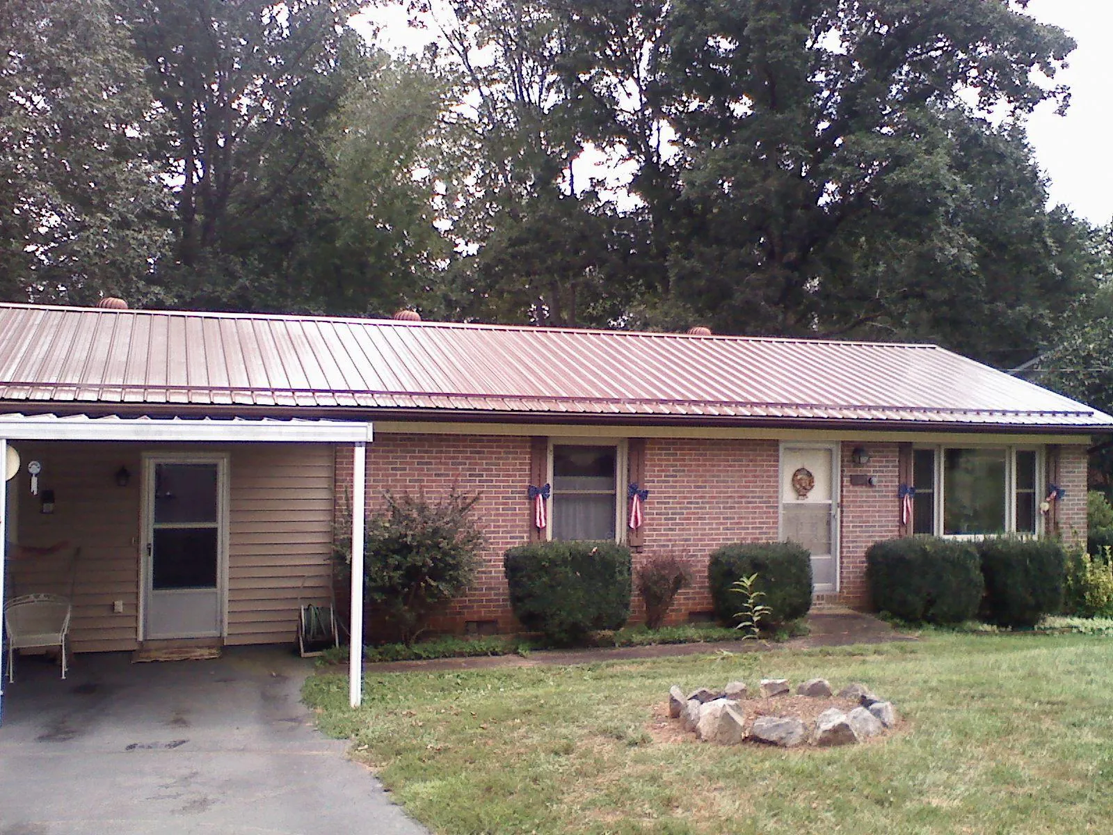 Bronze metal roof and carport on a brick ranch home — Roof Repair work by our crew in North Myrtle Beach