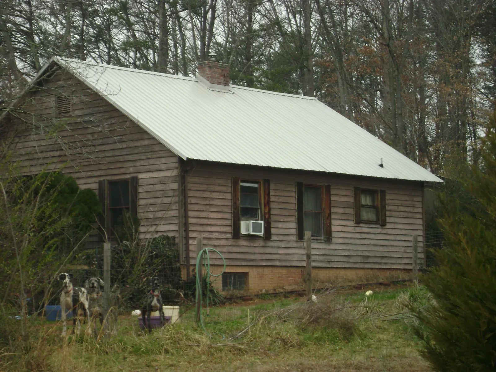 White metal roof on an old wood sided farmhouse, from a Metal Roof Installation job in North Myrtle Beach